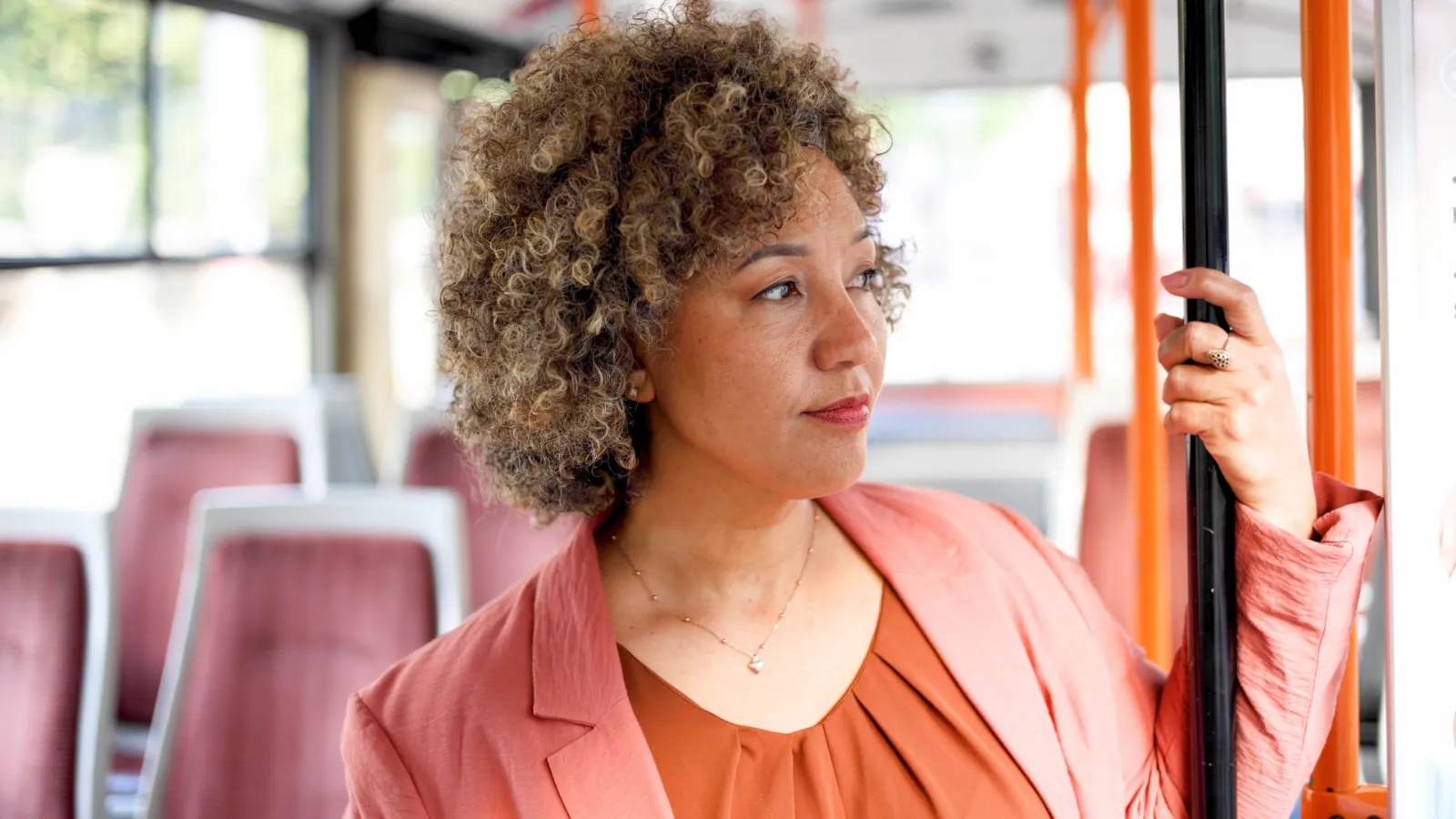 Kvinna klädd i rosa på en buss