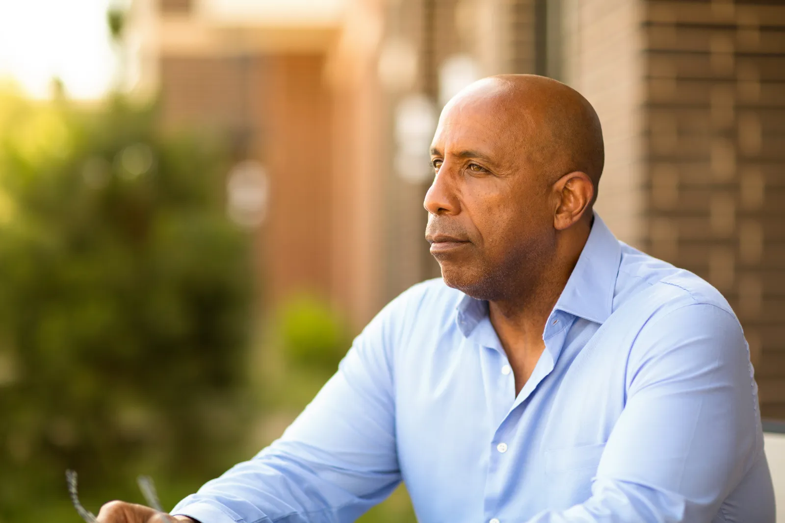 Man with blue shirt sitting outside