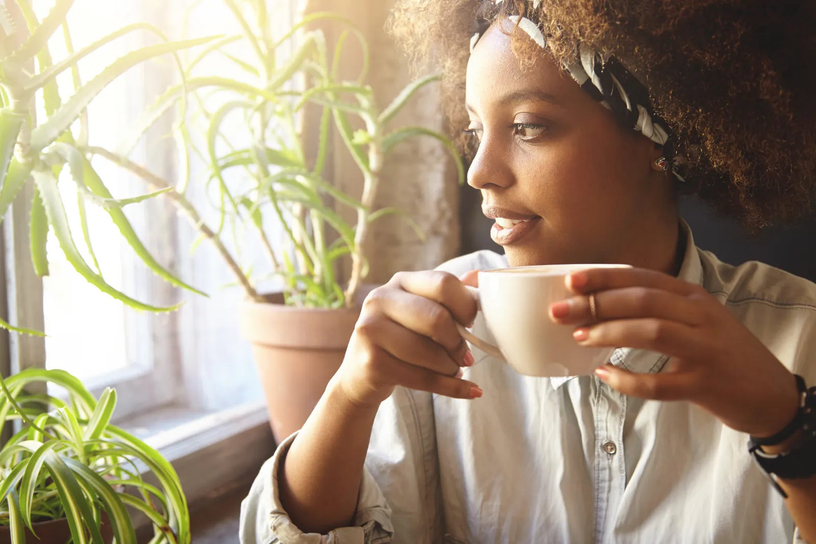 Woman with coffee looking out of window